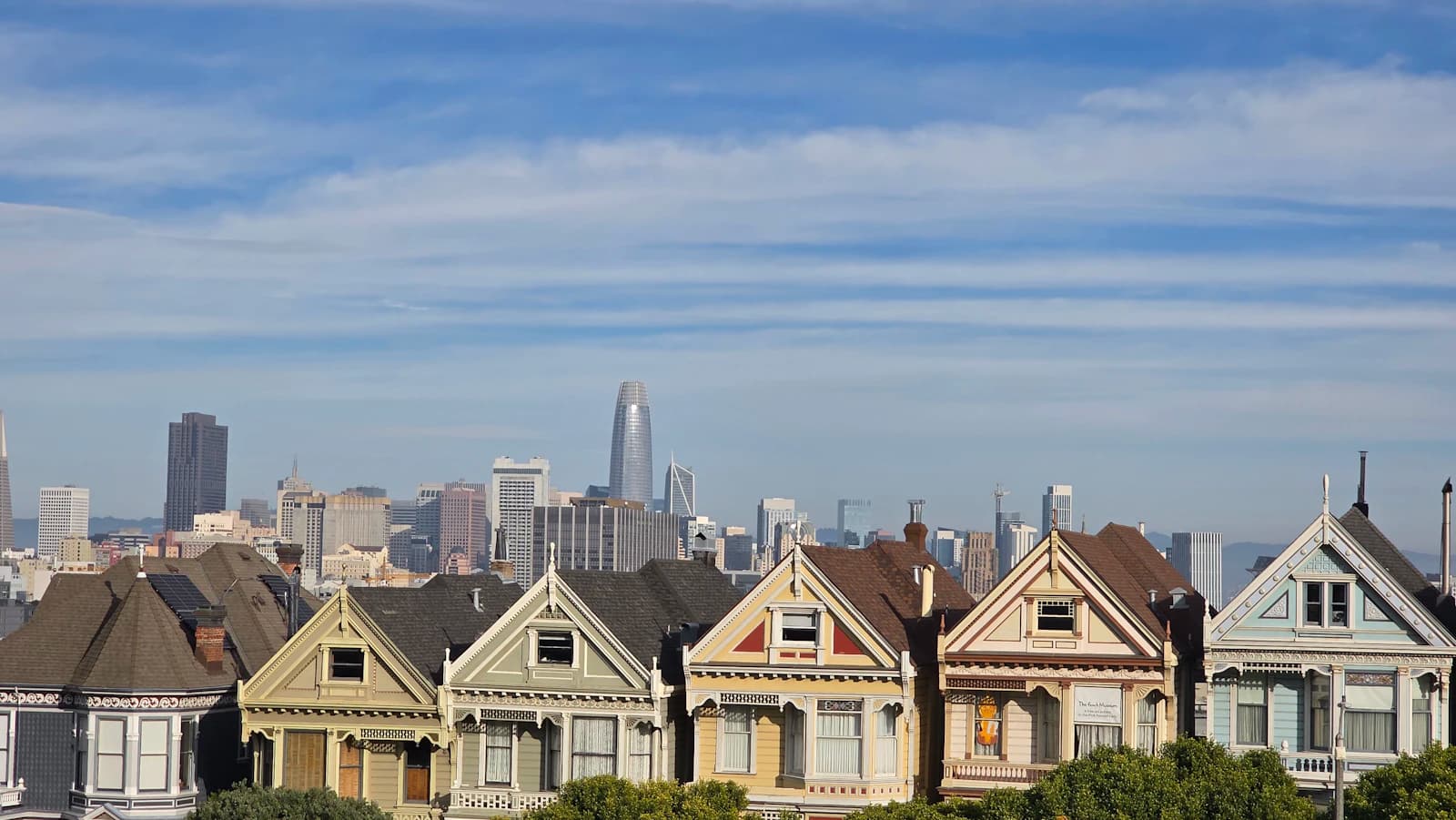 Painted houses in San Francisco with the downtown skyline behind them